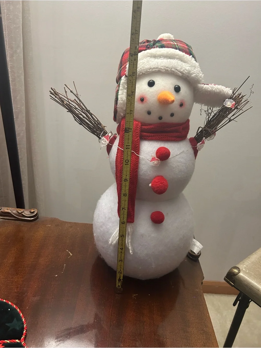 Snowman decoration with twig arms, plaid hat and Santa accent lights New